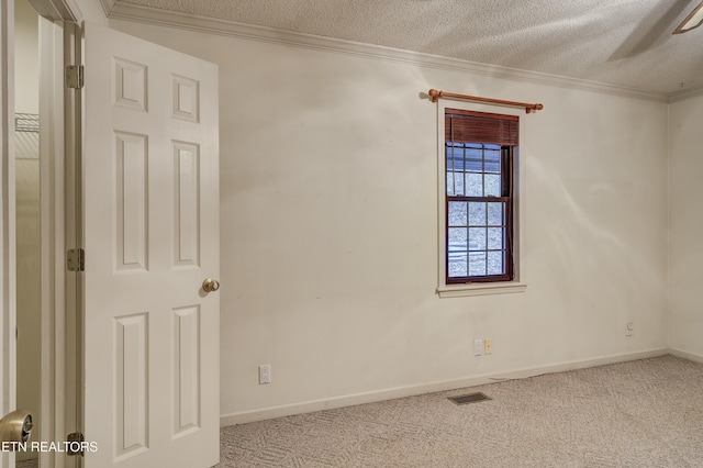 spare room featuring a textured ceiling, crown molding, and light colored carpet