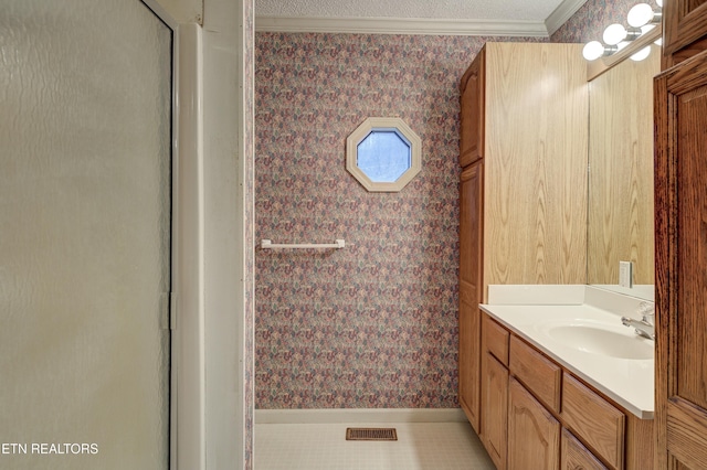 bathroom featuring walk in shower, vanity, tile patterned flooring, and crown molding