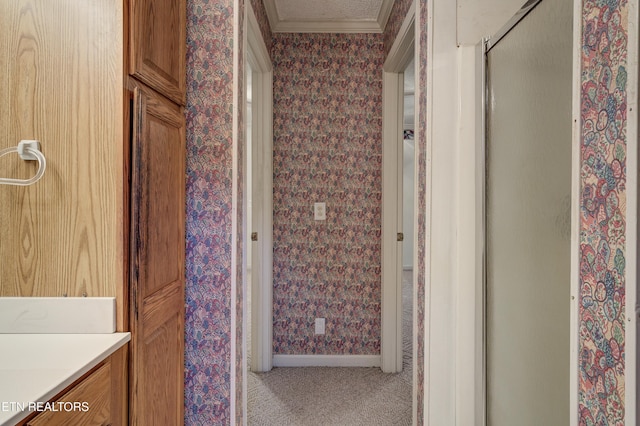 bathroom with a shower with door, crown molding, and vanity