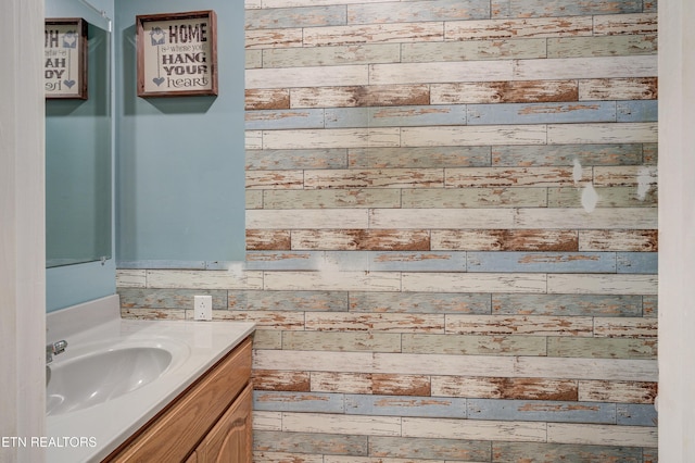 bathroom featuring wooden walls and vanity