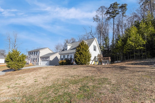 view of side of home featuring a garage and a lawn