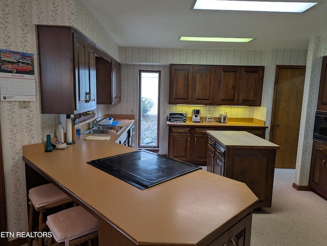 124 Sugarbush Cir, Crossville, TN 38558 - kitchen featuring dark brown cabinetry, a kitchen island, a sink, a peninsula, and wallpapered walls
