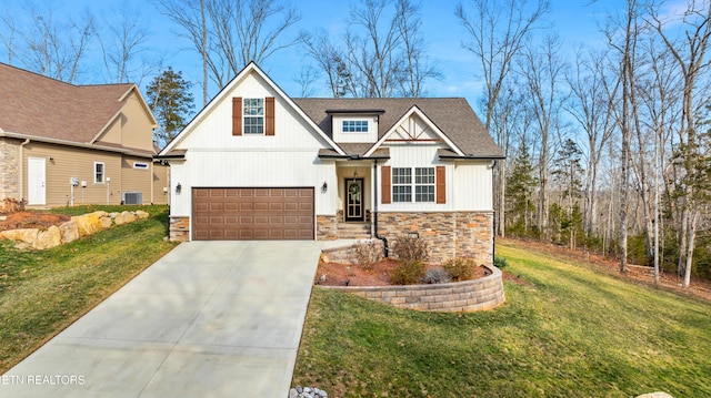 view of front of home with a garage, a front yard, and central AC unit