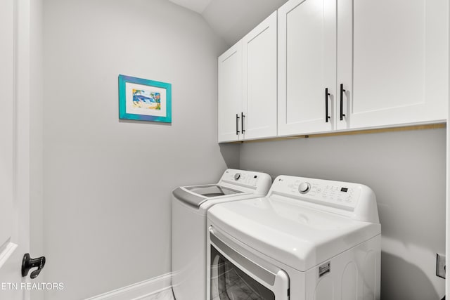 washroom featuring cabinets and washing machine and clothes dryer