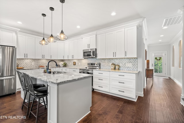 kitchen with sink, light stone counters, a center island with sink, appliances with stainless steel finishes, and white cabinets