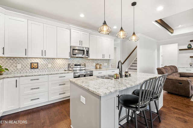 kitchen featuring white cabinetry, appliances with stainless steel finishes, sink, and a kitchen island with sink