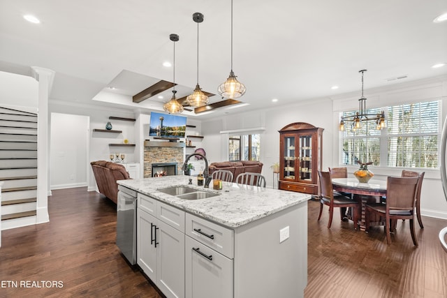 kitchen featuring sink, white cabinetry, a center island with sink, dishwasher, and light stone countertops