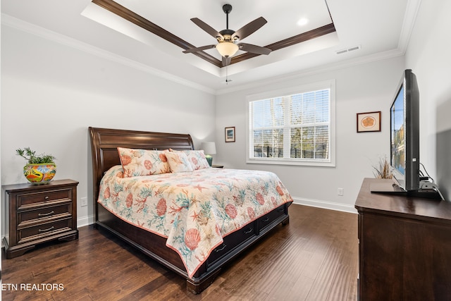 bedroom with crown molding, a tray ceiling, dark hardwood / wood-style floors, and ceiling fan