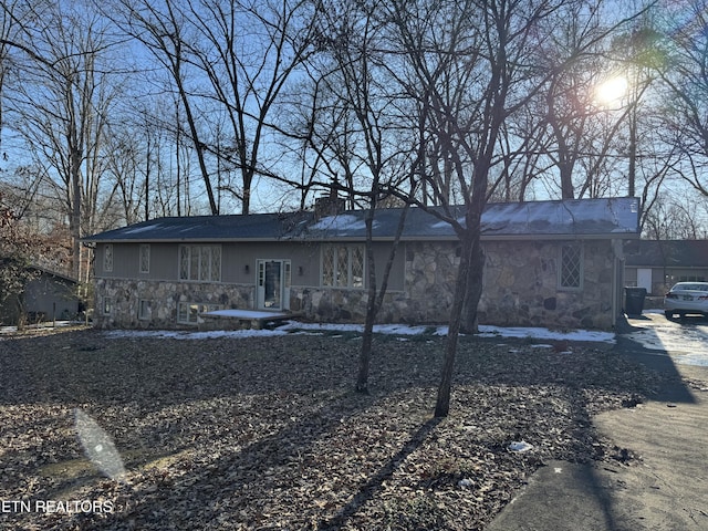 back of house featuring stone siding