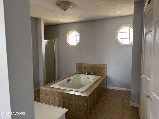 bathroom with a stall shower, a garden tub, a wealth of natural light, and tile patterned floors