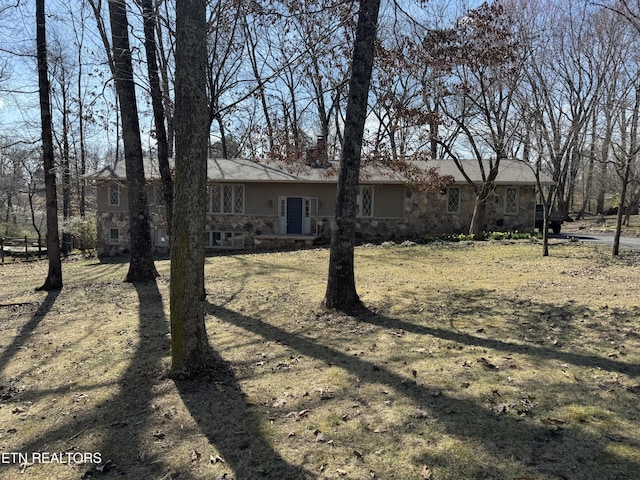 exterior space featuring stone siding and a chimney