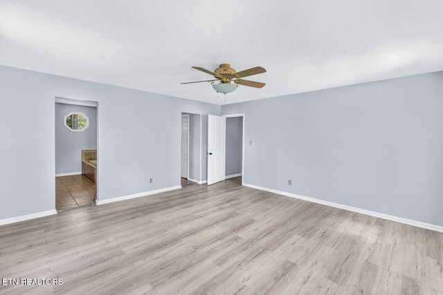 8305 Sharp Rd, Powell, TN 37849 - unfurnished bedroom with baseboards, light wood finished floors, ensuite bath, a ceiling fan, and a textured ceiling
