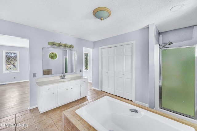 8305 Sharp Rd, Powell, TN 37849 - full bath featuring a garden tub, baseboards, vanity, tile patterned floors, and a textured ceiling