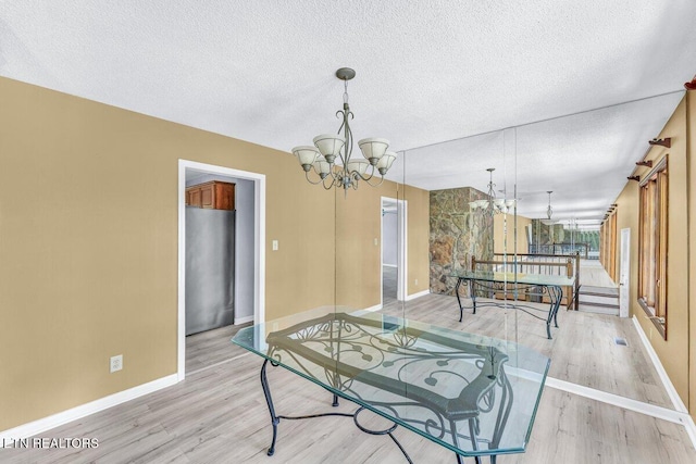 8305 Sharp Rd, Powell, TN 37849 - dining space with a chandelier, a textured ceiling, light wood finished floors, and baseboards