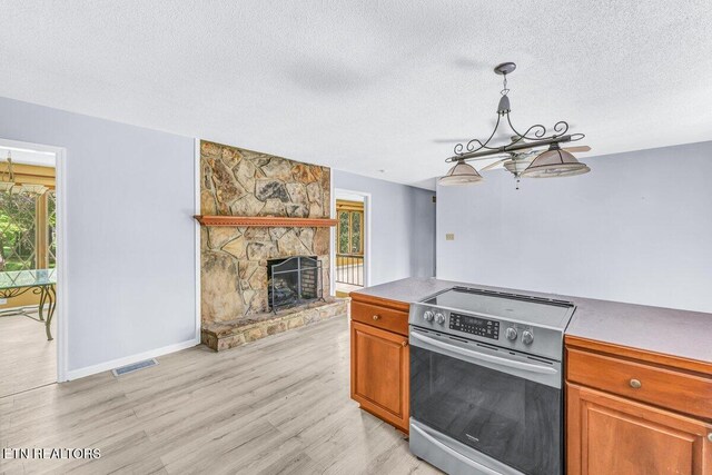 8305 Sharp Rd, Powell, TN 37849 - kitchen featuring stainless steel electric stove, a chandelier, light wood-style floors, a textured ceiling, and a fireplace