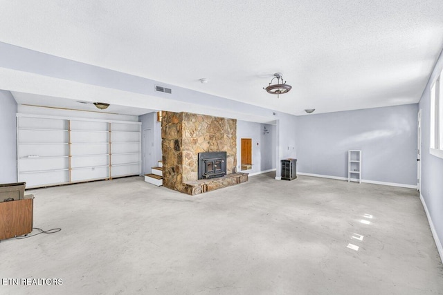 8305 Sharp Rd, Powell, TN 37849 - unfurnished living room with concrete flooring, a wood stove, a textured ceiling, and baseboards