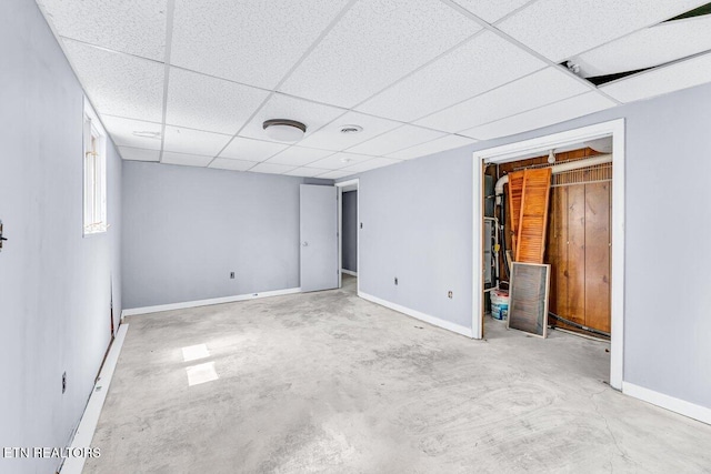 8305 Sharp Rd, Powell, TN 37849 - unfurnished bedroom featuring unfinished concrete floors, a paneled ceiling, baseboards, a spacious closet, and a closet