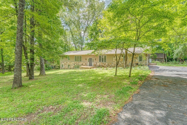 8305 Sharp Rd, Powell, TN 37849 - view of front of property featuring stone siding, asphalt driveway, and a front yard