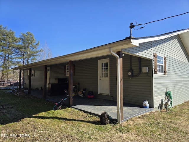 rear view of property featuring a yard and a patio