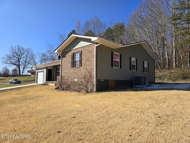 view of property exterior with a garage, cooling unit, and a lawn