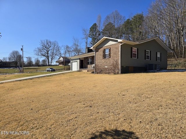 view of front facade featuring a front lawn, a garage, and central AC