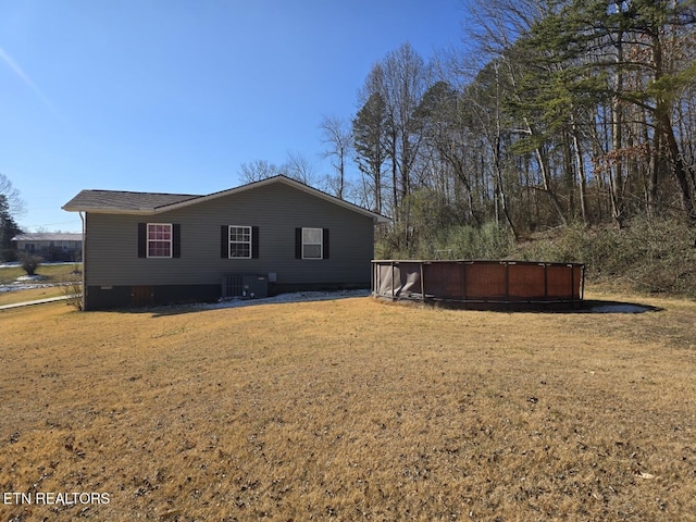 back of property featuring cooling unit and a yard