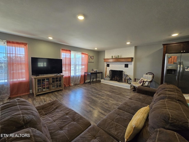 living room featuring dark hardwood / wood-style floors, a healthy amount of sunlight, and a fireplace