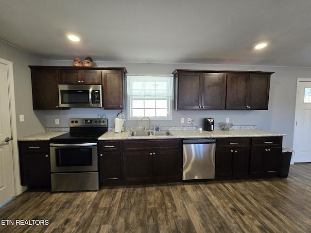 kitchen with sink, dark brown cabinetry, appliances with stainless steel finishes, and dark hardwood / wood-style floors