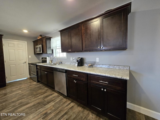 kitchen with dark brown cabinets, sink, stainless steel appliances, and dark hardwood / wood-style floors