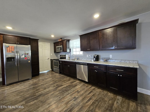 kitchen featuring sink, dark brown cabinetry, dark hardwood / wood-style flooring, and stainless steel appliances