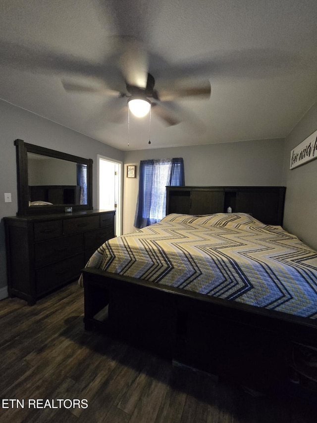 bedroom with ceiling fan, a textured ceiling, and dark hardwood / wood-style flooring