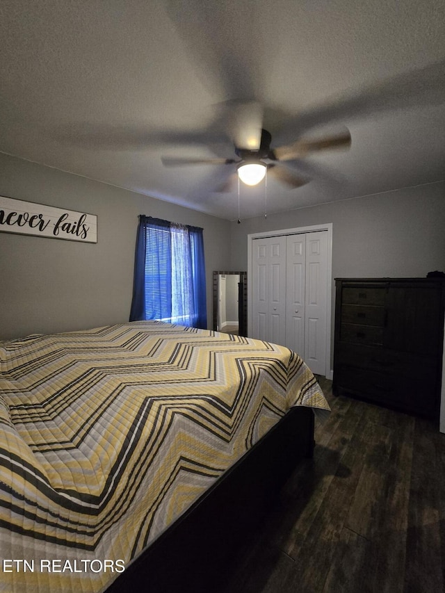 bedroom with ceiling fan, a closet, dark wood-type flooring, and a textured ceiling