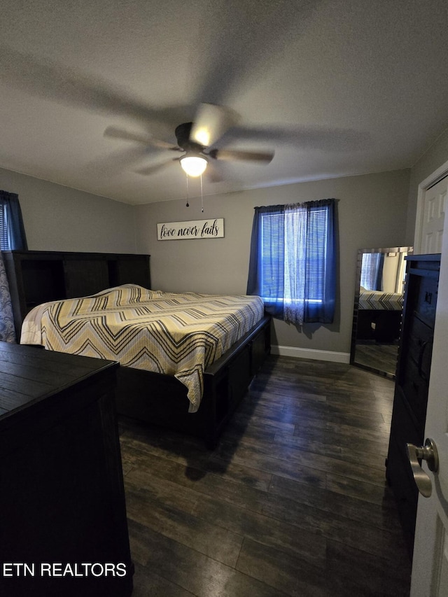 bedroom with a textured ceiling, ceiling fan, and dark hardwood / wood-style flooring