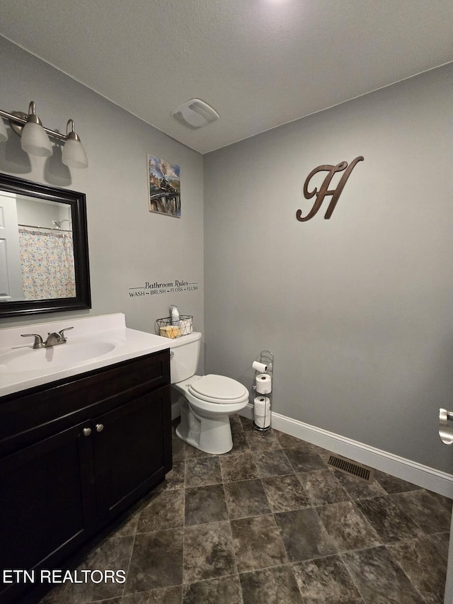 bathroom featuring toilet and vanity