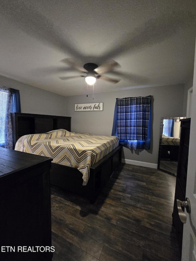 bedroom featuring ceiling fan, dark wood-type flooring, and a textured ceiling