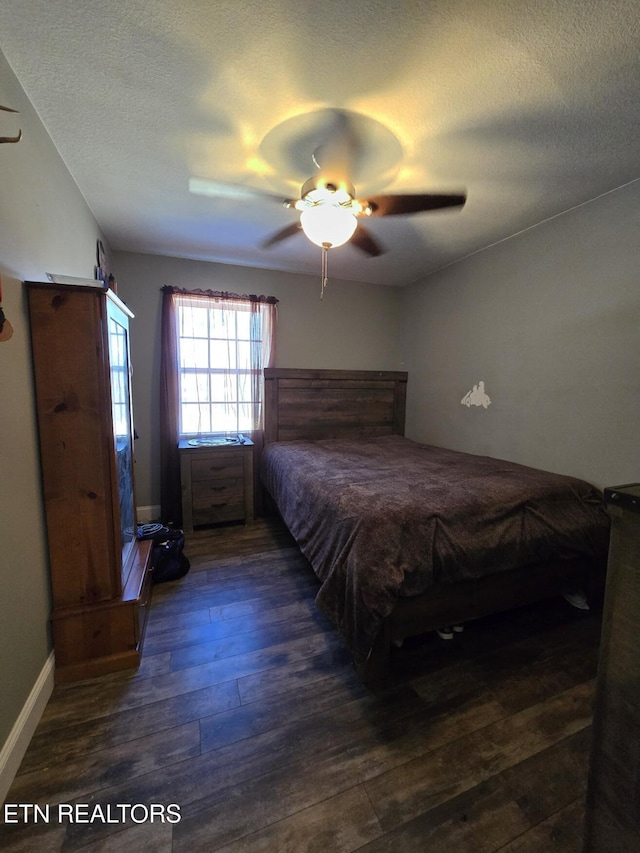 unfurnished bedroom featuring ceiling fan, dark wood-type flooring, and a textured ceiling