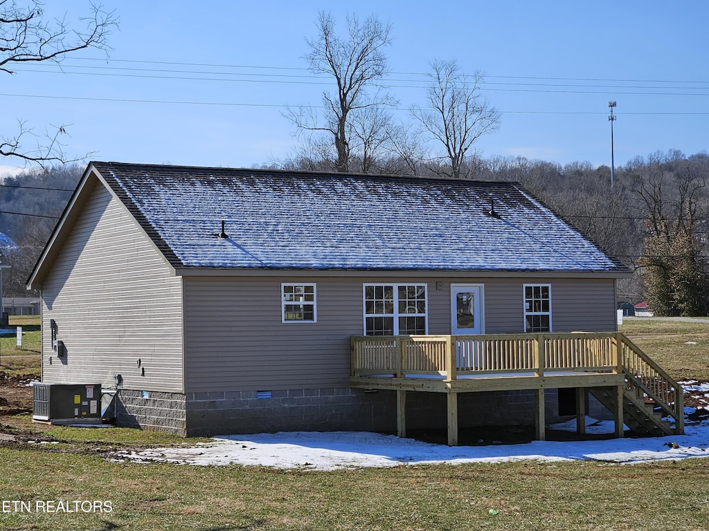 rear view of property featuring central AC and a wooden deck