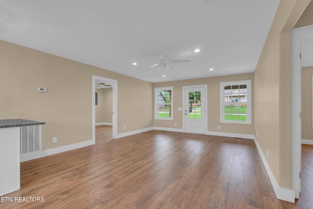 unfurnished living room with ceiling fan, hardwood / wood-style flooring, plenty of natural light, baseboards, and recessed lighting