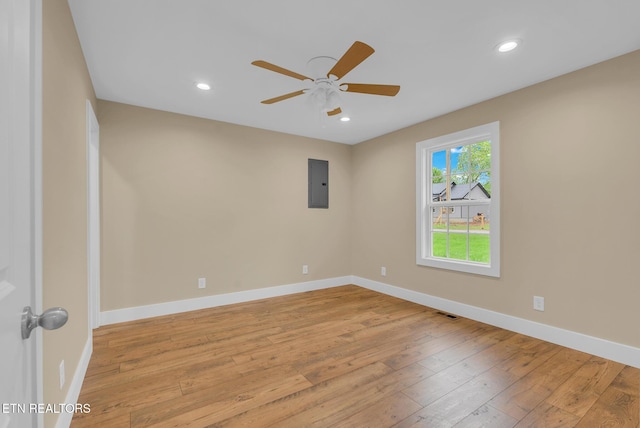 unfurnished room featuring light wood-style floors, electric panel, a ceiling fan, baseboards, and recessed lighting