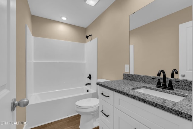 bathroom with wood finished floors, toilet, shower / tub combination, and vanity