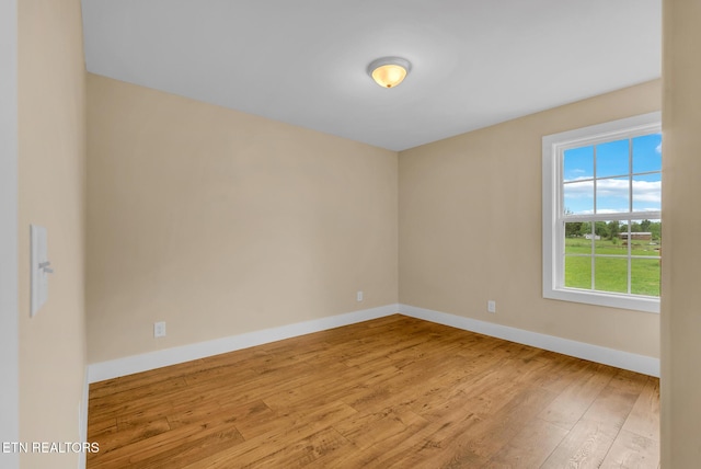 unfurnished room with hardwood / wood-style flooring and baseboards