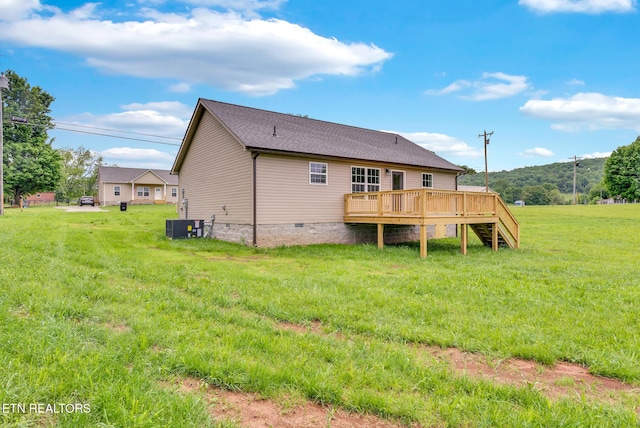 back of house featuring a wooden deck, crawl space, a lawn, and roof with shingles