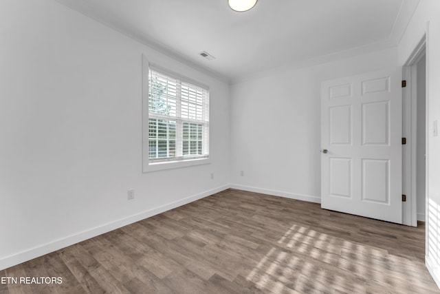 unfurnished room with ornamental molding and wood-type flooring