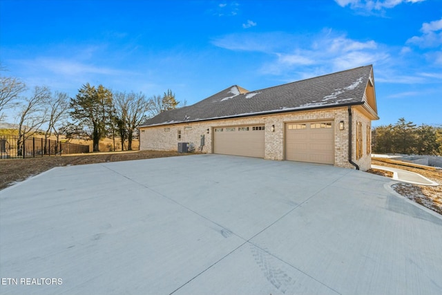 view of home's exterior with a garage and central AC