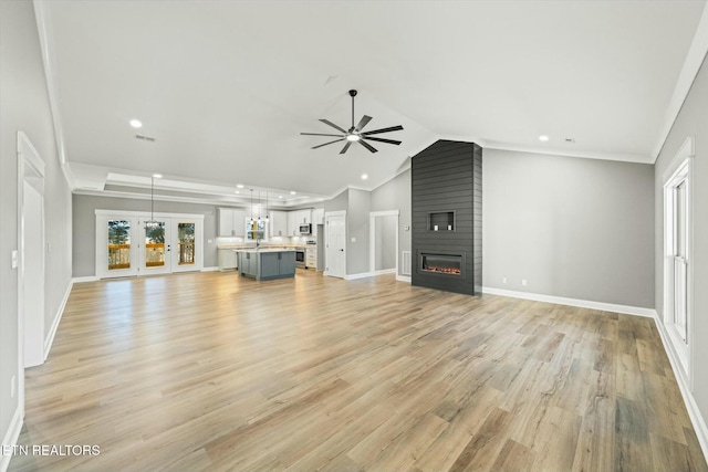 unfurnished living room featuring crown molding, light hardwood / wood-style flooring, ceiling fan, a large fireplace, and vaulted ceiling