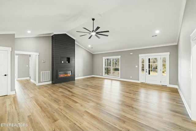 unfurnished living room with crown molding, a large fireplace, lofted ceiling, and light hardwood / wood-style flooring