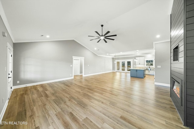 unfurnished living room featuring ceiling fan, a large fireplace, light hardwood / wood-style floors, and vaulted ceiling