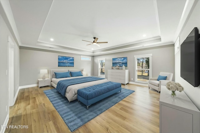 bedroom with a raised ceiling, ceiling fan, and light hardwood / wood-style floors