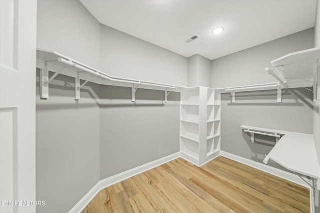 spacious closet with hardwood / wood-style flooring