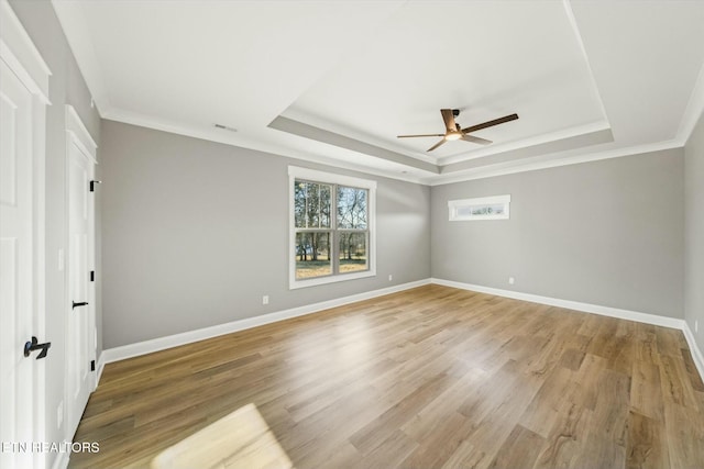 spare room with hardwood / wood-style flooring, ornamental molding, and a raised ceiling